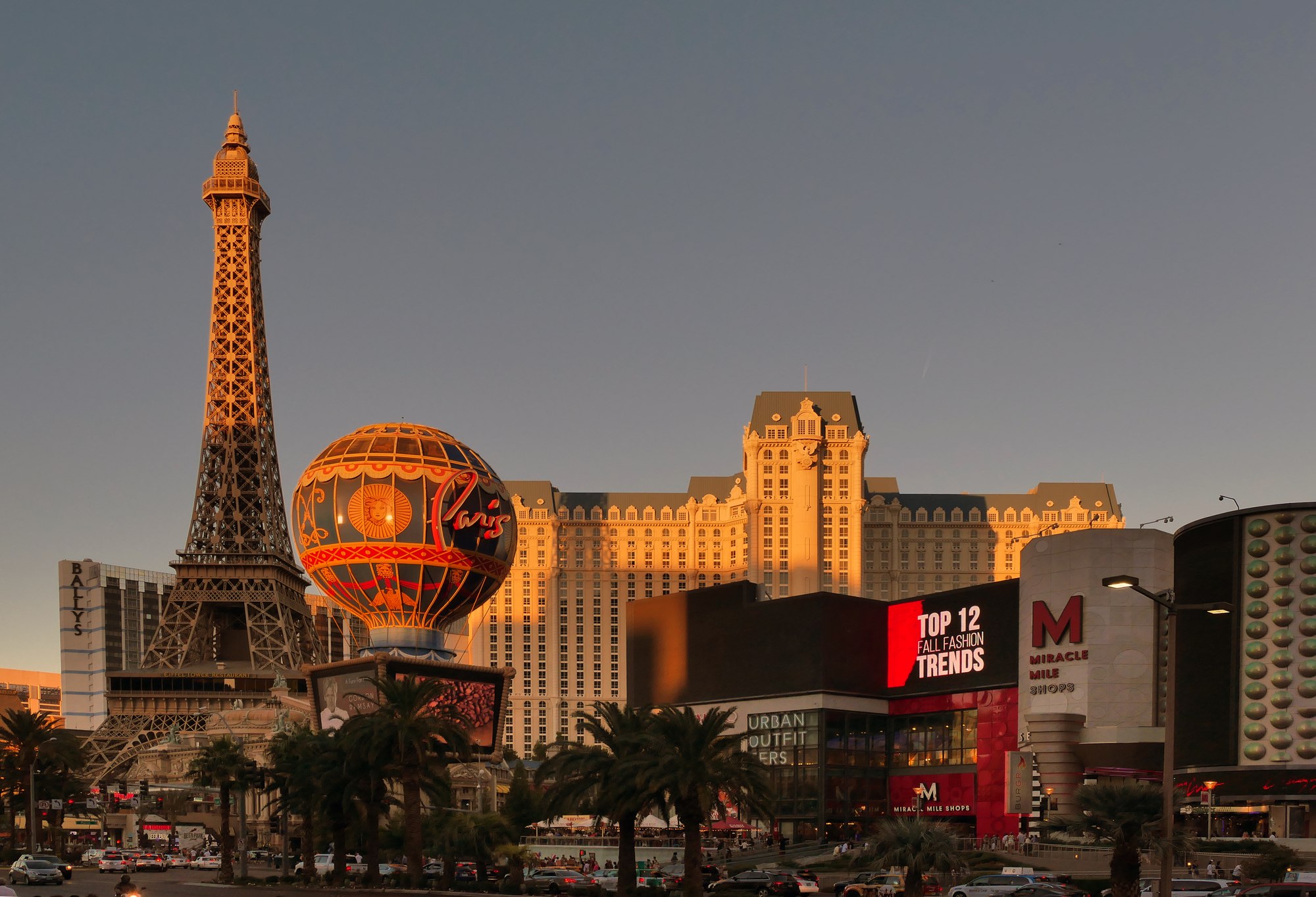 The Paris Las Vegas Eiffel Tower replica, balloon sign and hotel overlook Las Vegas Boulevard in warm sunlight.
